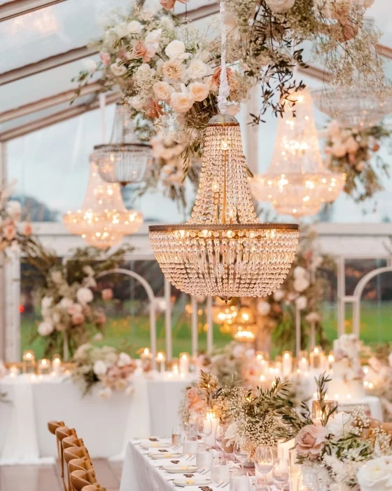 Decorative chandelier with floral arrangements and candles in an outdoor setting