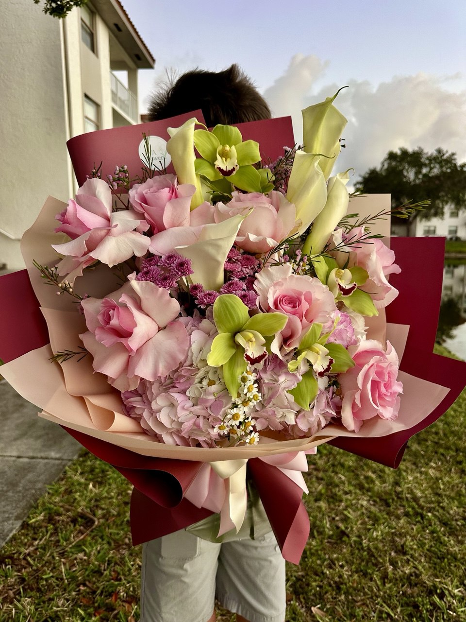 Person holding a large bouquet of flowers outdoors. Premium florist in Florida Hollywood.