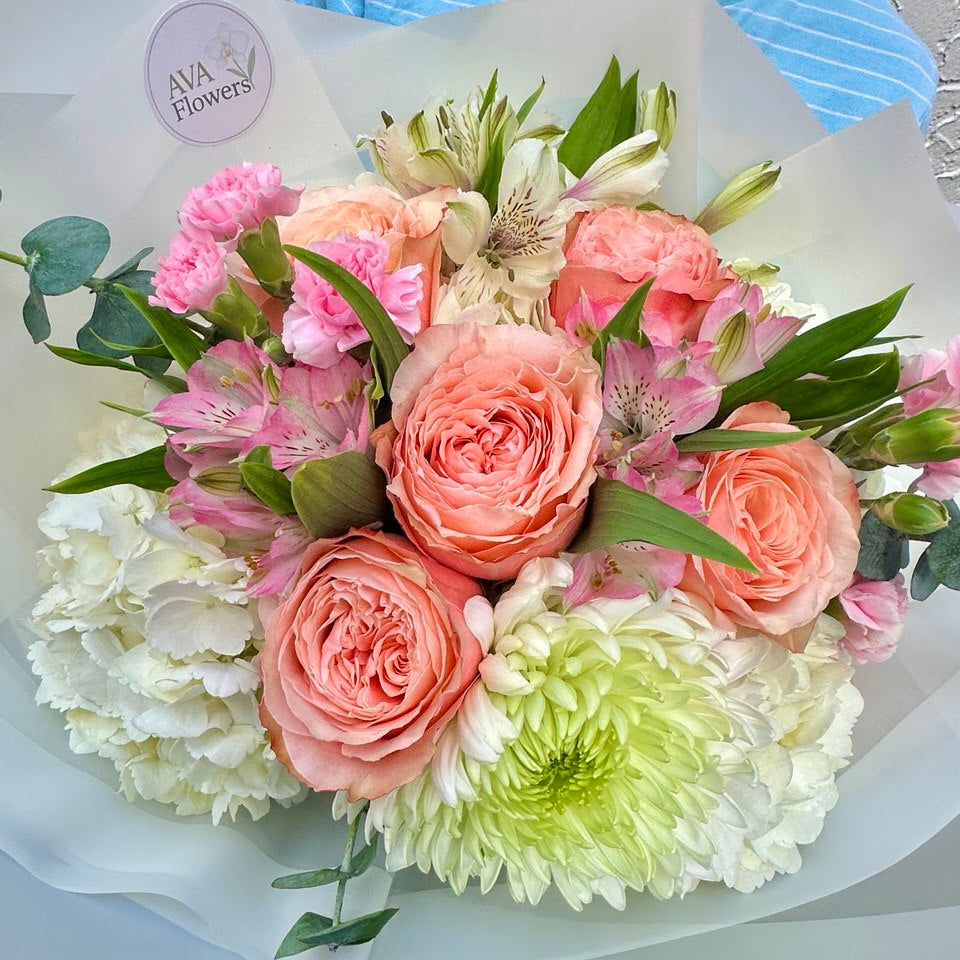 Bouquet of pink and white flowers with a visible brand label on a light background