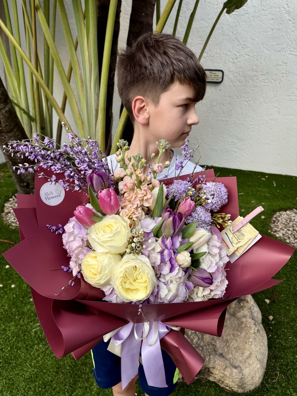 Child holding a bouquet of flowers outdoors